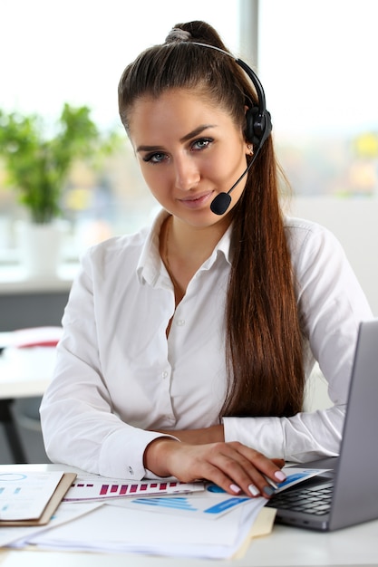 Beautiful brunette smiling call centre clerk at work