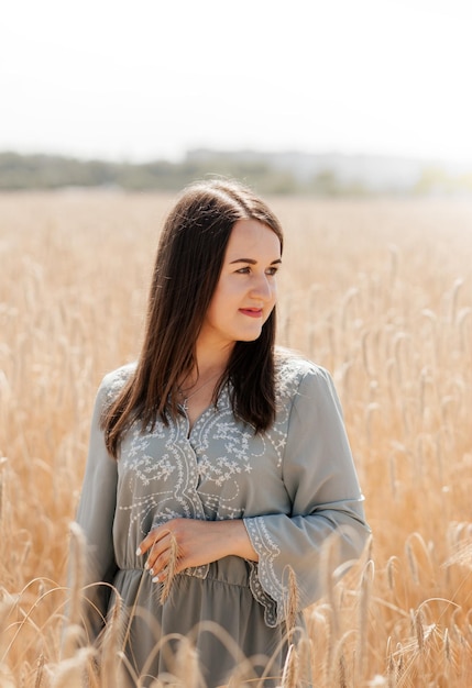 Beautiful Brunette standing in a Wheat Field