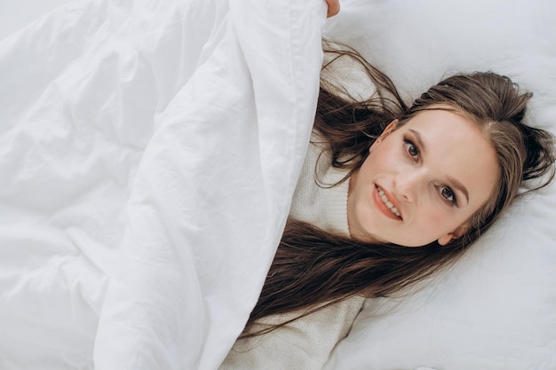 Beautiful brunette woman in bed close-up