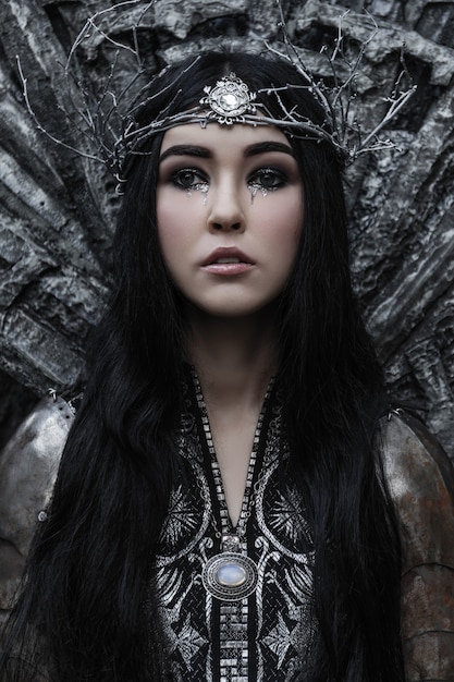 Beautiful brunette woman in a black and silver dress and armor