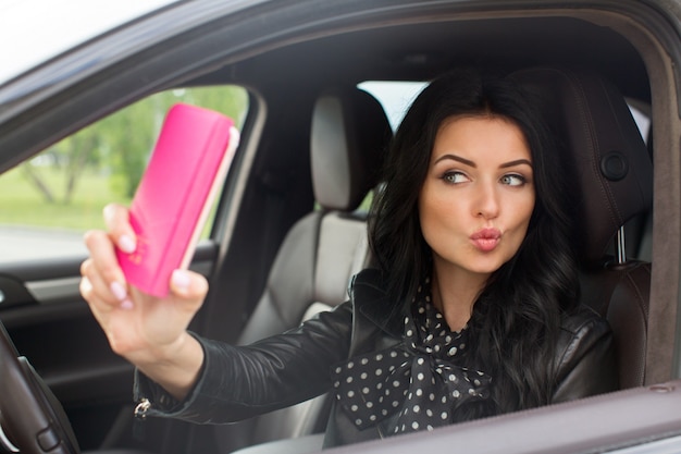 美しいブルネットの女性は、車でセルフをやって