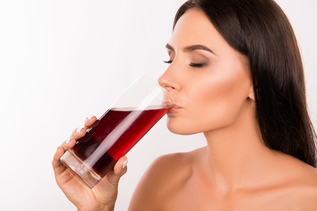 Beautiful brunette woman drinking cherry juice