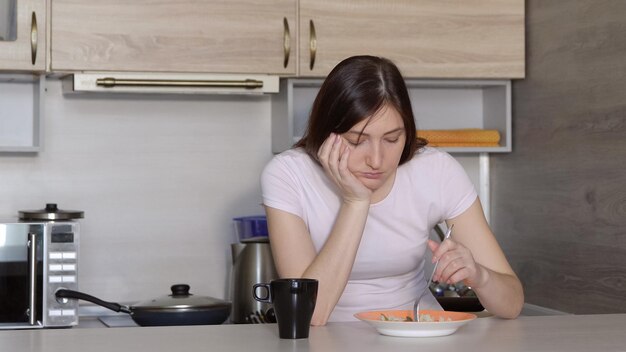 野菜とご飯を食べる美しいブルネットの女性。