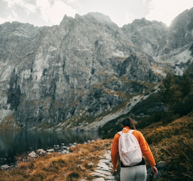 A beautiful brunette woman is hiking in the mountains of Europe Young girl relaxing in the Tatra Mountains Concept of a healthy active life outdoor