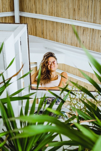 Beautiful brunette woman in loft home in tropical location.