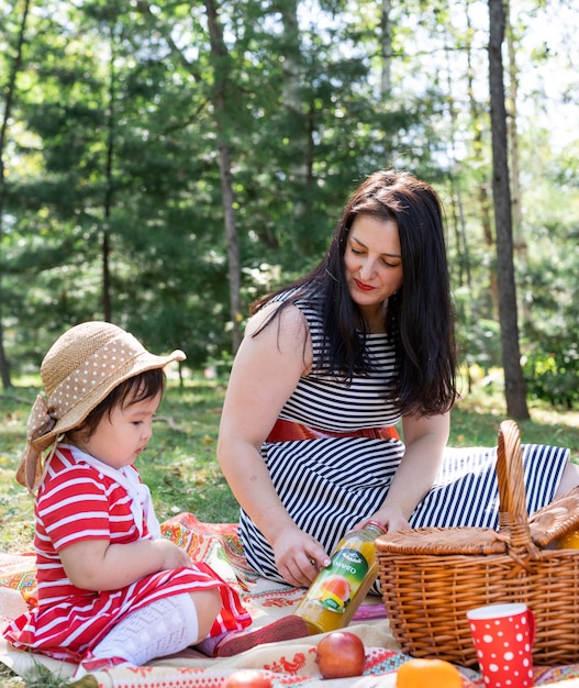 Beautiful brunette woman in a striped dress with her kid