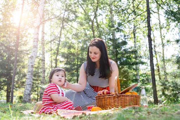 Beautiful brunette woman in a striped dress with her kid