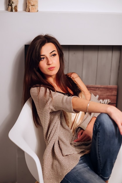 Beautiful brunette woman in a sweater at home