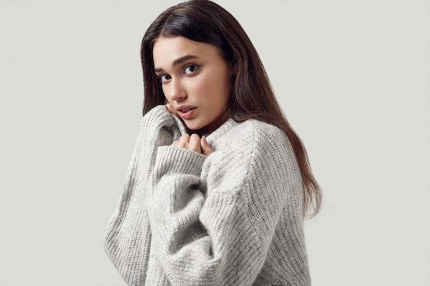 Beautiful brunette woman in sweater posing 