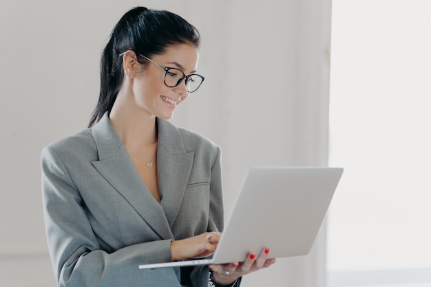 Bella donna castana che utilizza un computer portatile