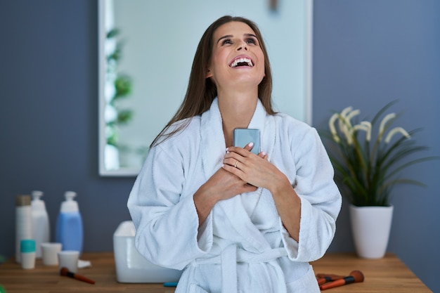 Foto bella donna bruna con smartphone in bagno