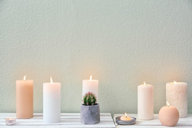 Beautiful burning candles on table on white