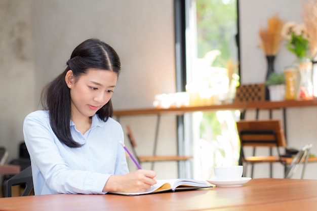 Красивая бизнес-азии молодая женщина, писать на ноутбуке на столе.