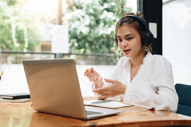 Bella donna d'affari piena di risorse che guarda il tavolo del taccuino guardando la formazione online mentalità sedersi sedia giacca formale blazer ufficio moderno