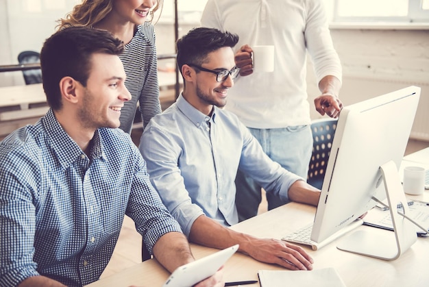 Beautiful business people are using computers and smiling while working in office