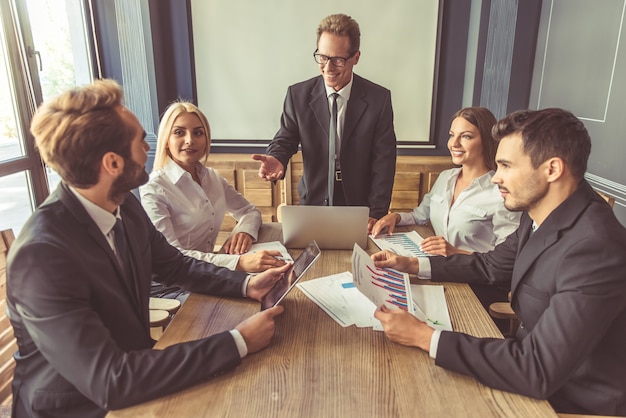 Beautiful business people in suits are discussing affairs