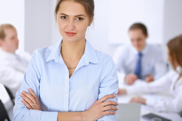 Beautiful business woman on the background of business people during meeting