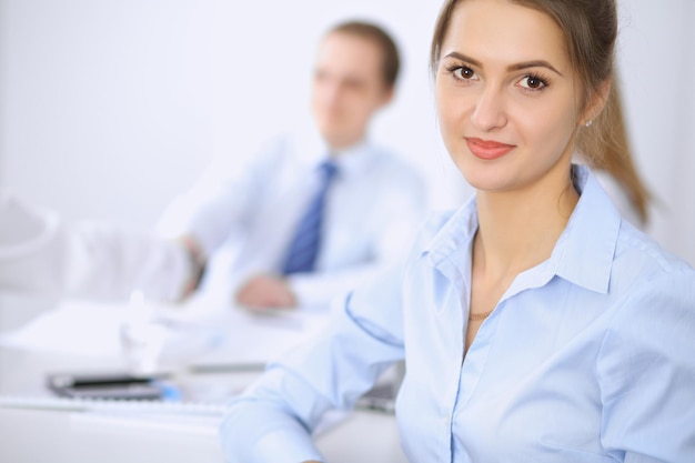 Beautiful business woman on the background of business people during meeting