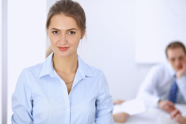 Beautiful business woman on the background of business people during meeting