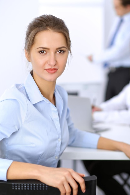 beautiful business woman on the background of business people during meeting
