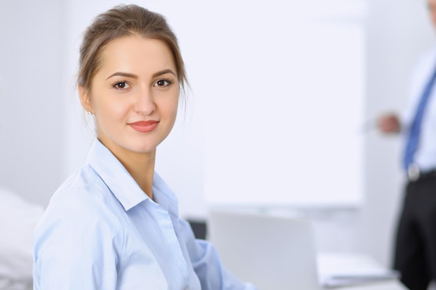 Beautiful business woman on the background of business people during meeting