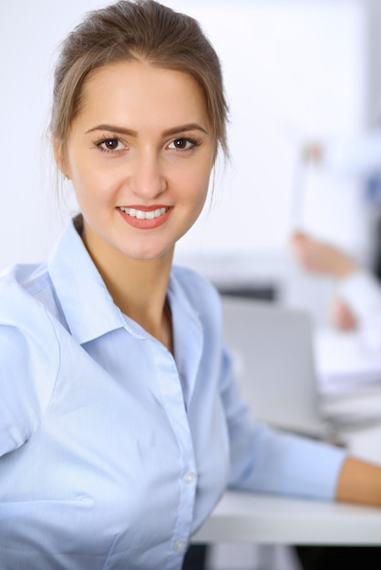 Beautiful business woman on the background of business people during meeting