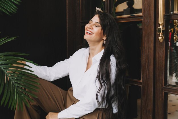 Beautiful business woman in a business suit posing near a glass door