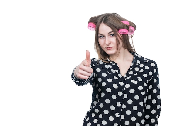 beautiful business woman in curlers aims finger like a gun at the camera isolated on white background