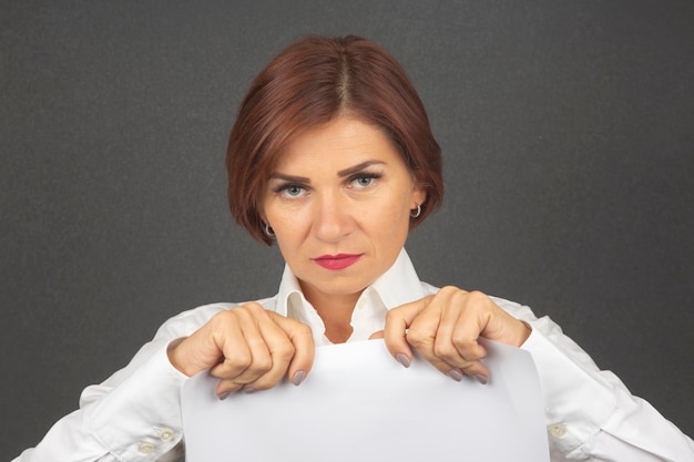 Beautiful business woman holding a white sheet of paper in her hands