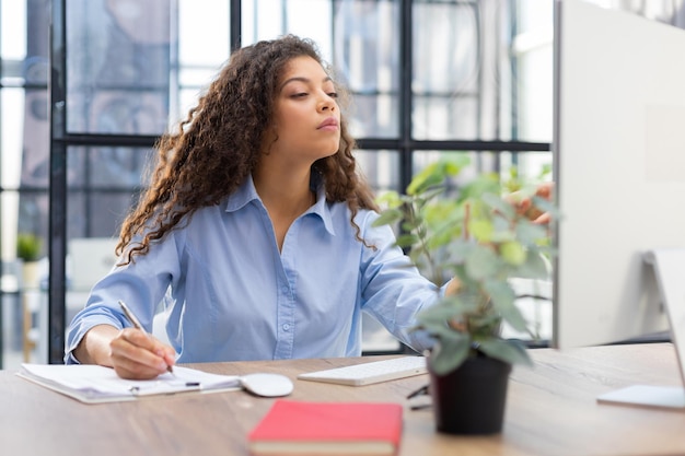 Beautiful business woman is examining documents while sitting in the office