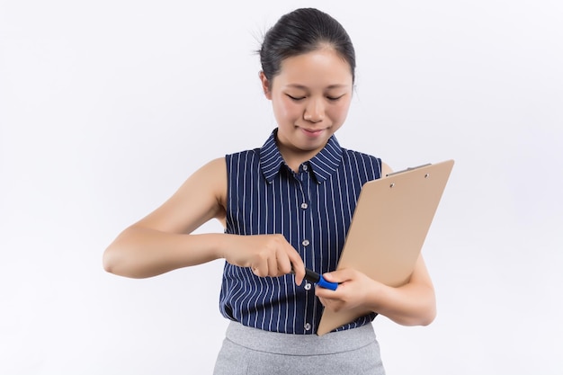 Beautiful business woman looking at papers she holding in her arms while working on computer at her office