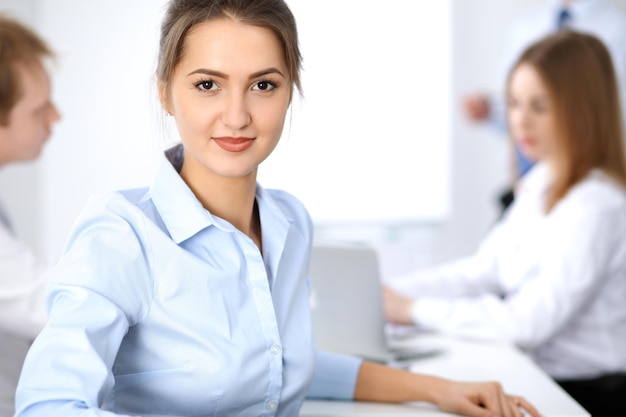 Beautiful business woman at meeting while sitting at the table