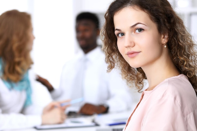 Beautiful business woman at meeting in white colored office background