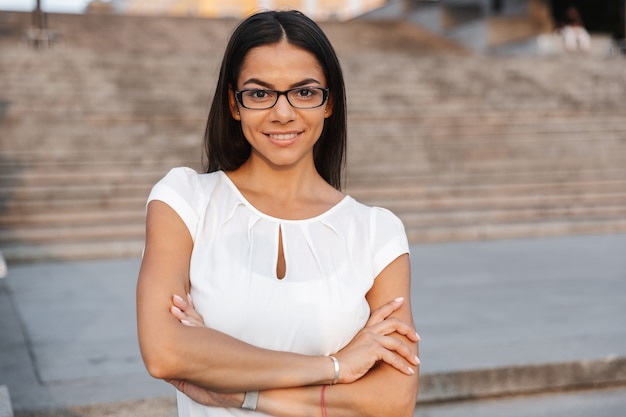 a beautiful business woman posing outdoors at the street looking camera