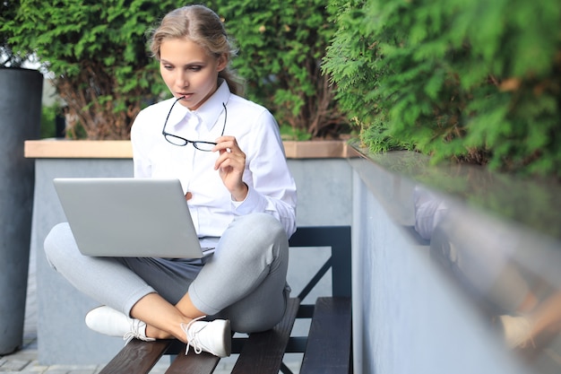 Beautiful business woman sitting near business center and using laptop.