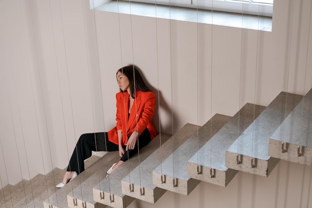 Beautiful business woman on stairs in red jacket is experiencing collapse