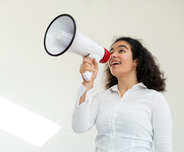 Beautiful business woman with curly hair holding a megaphone high quality photo