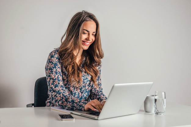 Beautiful business woman working on her laptop in an office environment.