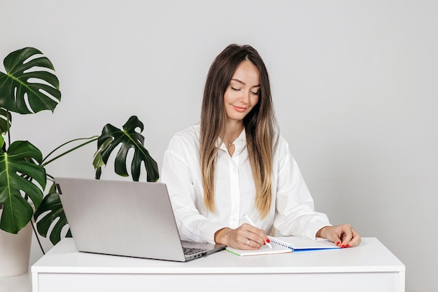 Beautiful business woman working in the office isolated over a white background