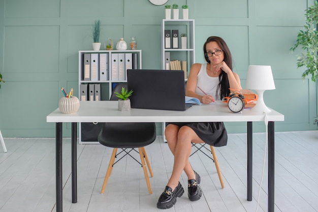 Bella donna d'affari lavora in ufficio su un laptop freelance al lavoro insegna l'insegnante