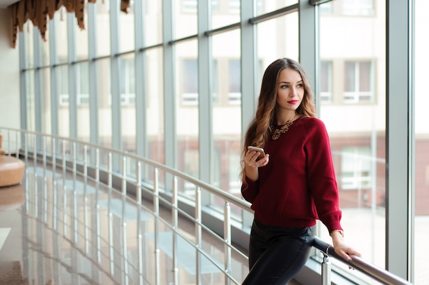 Beautiful business woman writing sms on a mobile phone