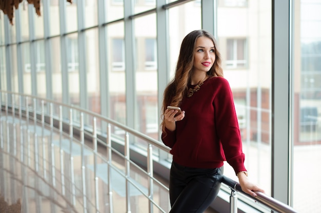 Beautiful business woman writing sms on a mobile phone