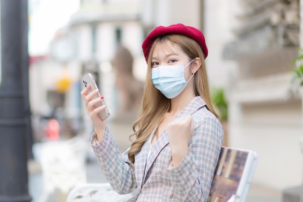 Beautiful business working Asian woman wears suitred cap and a medical face mask to protect