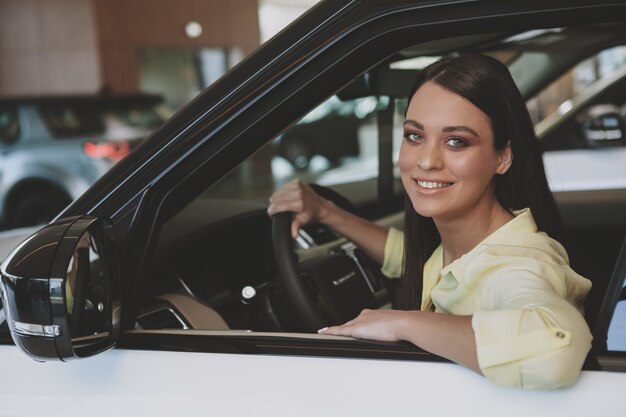 Beautiful businesswoman buying new automobile