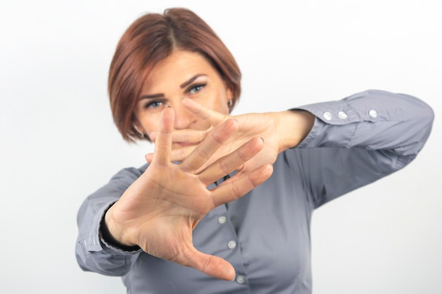 Foto bella donna d'affari esprime protesta emotiva e pensieri con le proprie mani su uno sfondo bianco