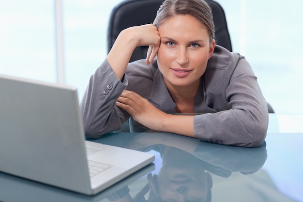Photo beautiful businesswoman leaning on her desk
