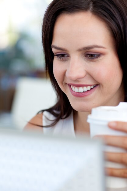 Beautiful businesswoman in office drinking coffee