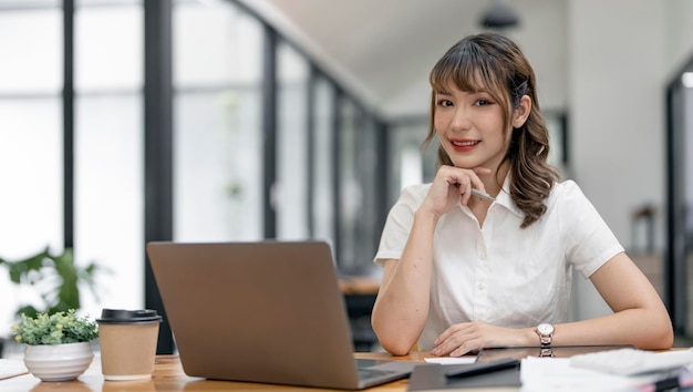 Beautiful businesswoman sitting and look at the camera at the office