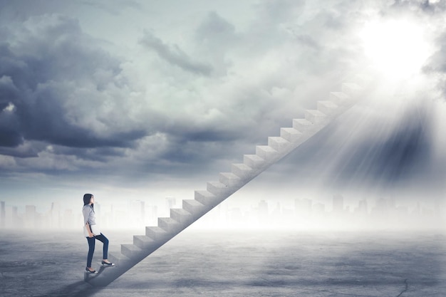 Beautiful businesswoman stepping up on the staircase