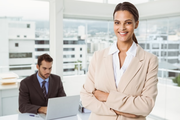 Beautiful businesswoman with arms crossed at office